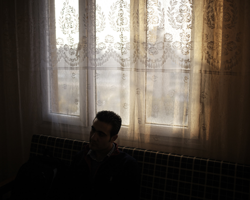 A journalist is listening to an activist (both are Syrian) in the activist's apartment. Antakya, Turkey.